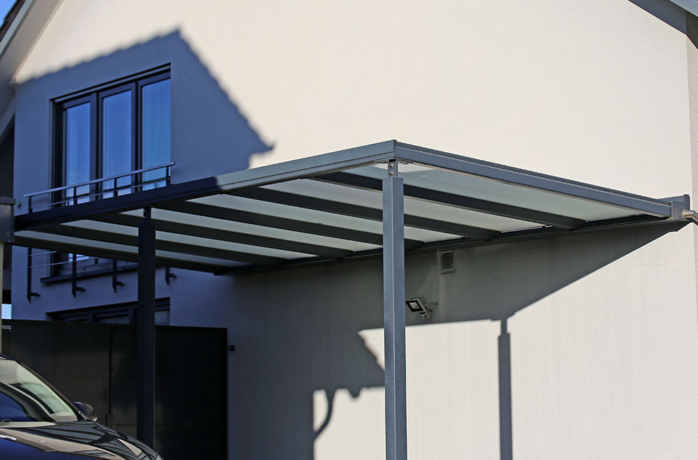 carport ou abris à voiture en métal le long d'une maison